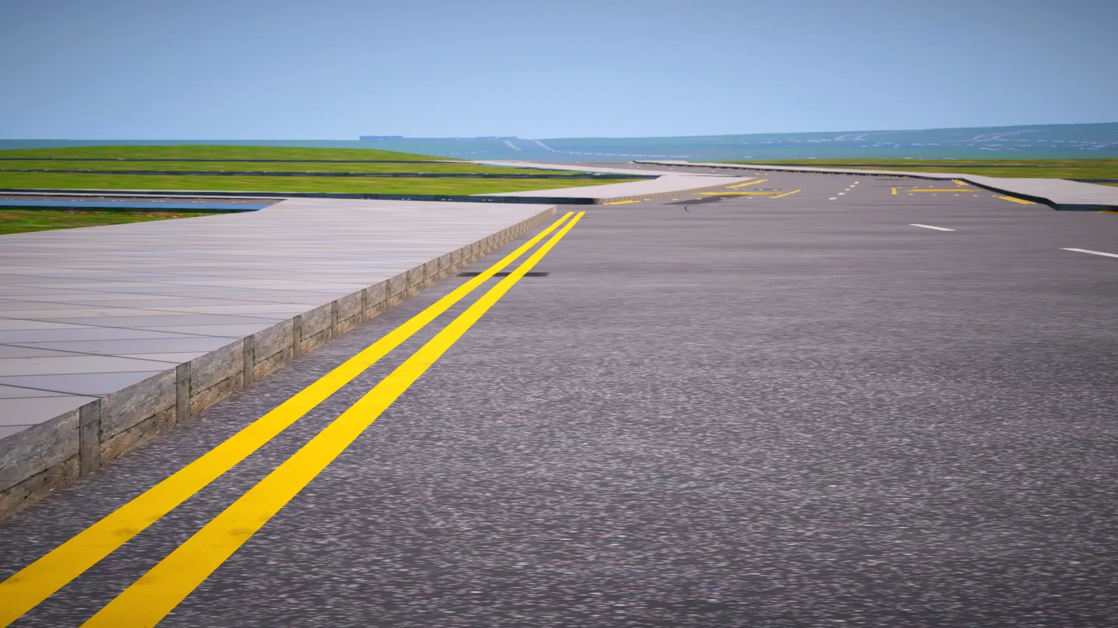 Close view of double yellow lines along a kerb, with the road curving away towards the sea.